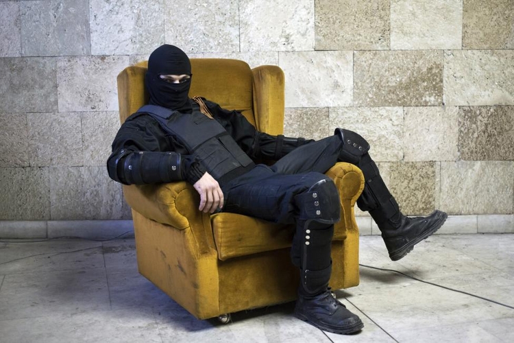 fot. Marko Djurica / Reuters / 30 kwietnia 2014  Donieck, Ukraina  Zamaskowany, prorosyjski protestujący pozuje na fotelu w rządowym budynku.